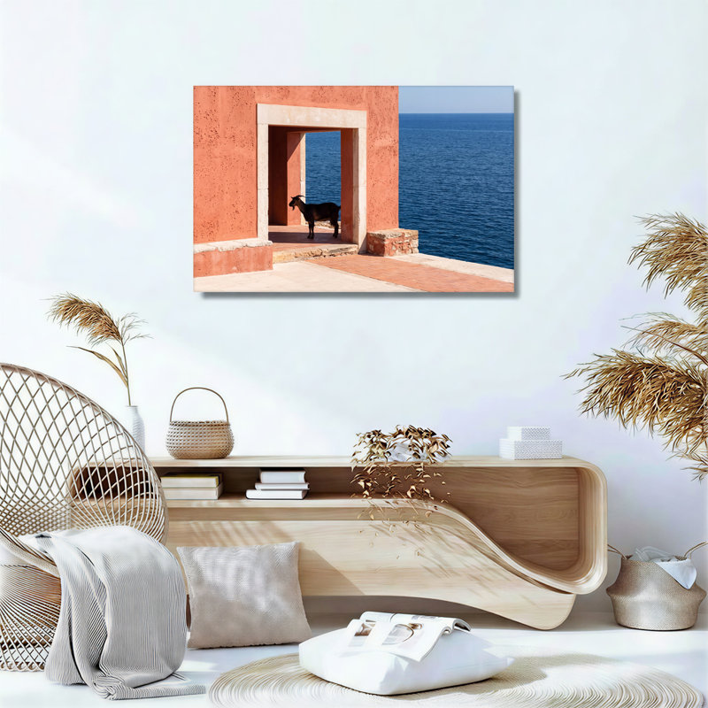 Chèvre noire debout dans une porte en terre cuite face à une toile bleue, 20"H x 30"W