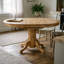 Ensemble de table et de chaises ovales en bois dur asiatique au fini chêne brun, avec rallonge papillon et piètement central unique.