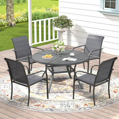 Ensemble repas pour 4 personnes avec table de salle à manger ronde et 4 chaises empilables en textilène