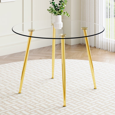 Table ronde avec plateau en verre et pieds ornés en métal doré
