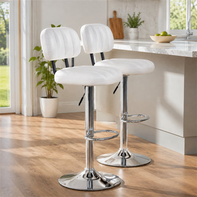 Un ensemble de deux tabourets de bar modernes réglables en hauteur avec des sièges rembourrés en polyuréthane blanc, des bases et des repose-pieds chromés pour les îlots de cuisine, les bars et les salons