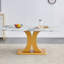 Une table de salle à manger minimaliste moderne. Plateau de table imitation verre marbré. Pieds de table en panneau de fibres à densité moyenne dorés pour la cuisine et le salon