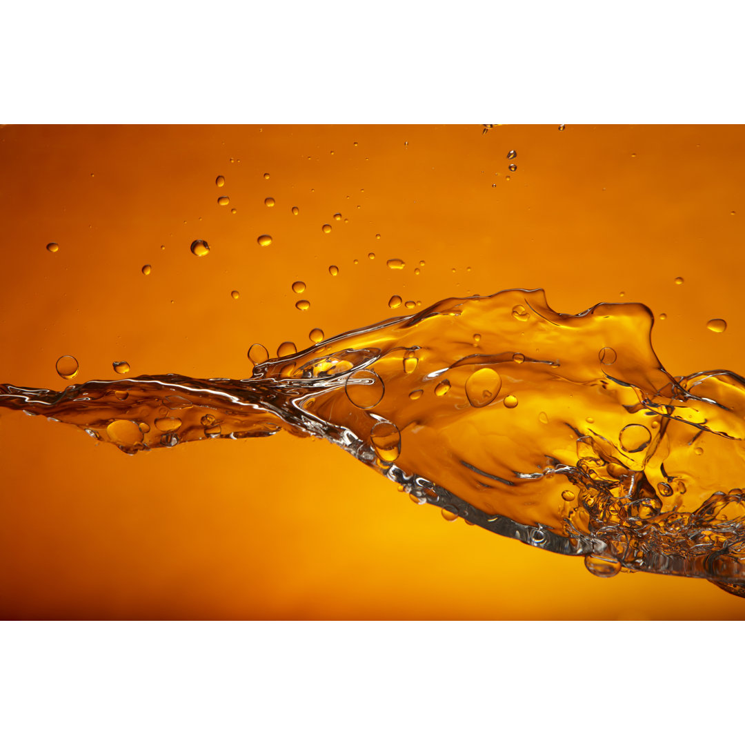 Wasserspritzer auf orangem Hintergrund von Hirko - Leinwandbild