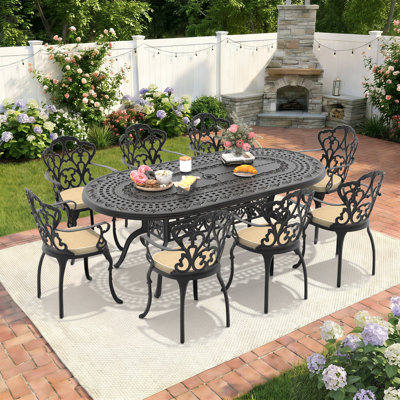 Ensemble repas de patio avec table ovale Suset, coussins blanc cassé inclus