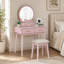 Charmante commode de coiffeuse à finition rose avec miroir, tabouret et tiroirs de rangement pour un décor de chambre à coucher élégant