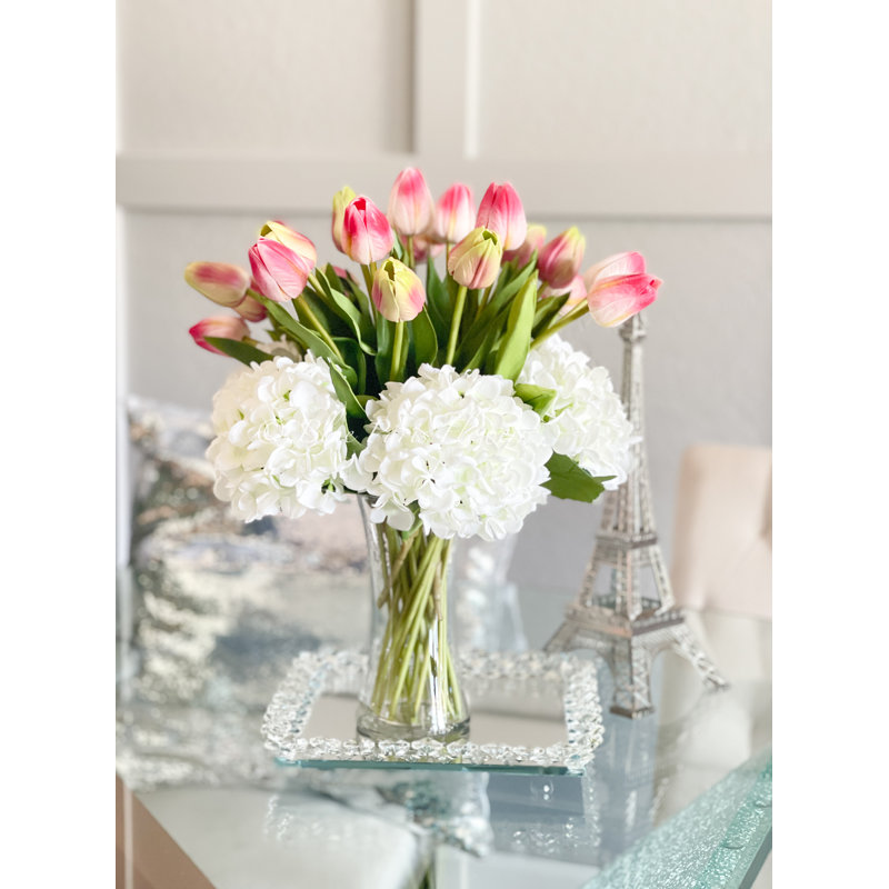 Vraies tulipes et hortensias dans un vase en verre