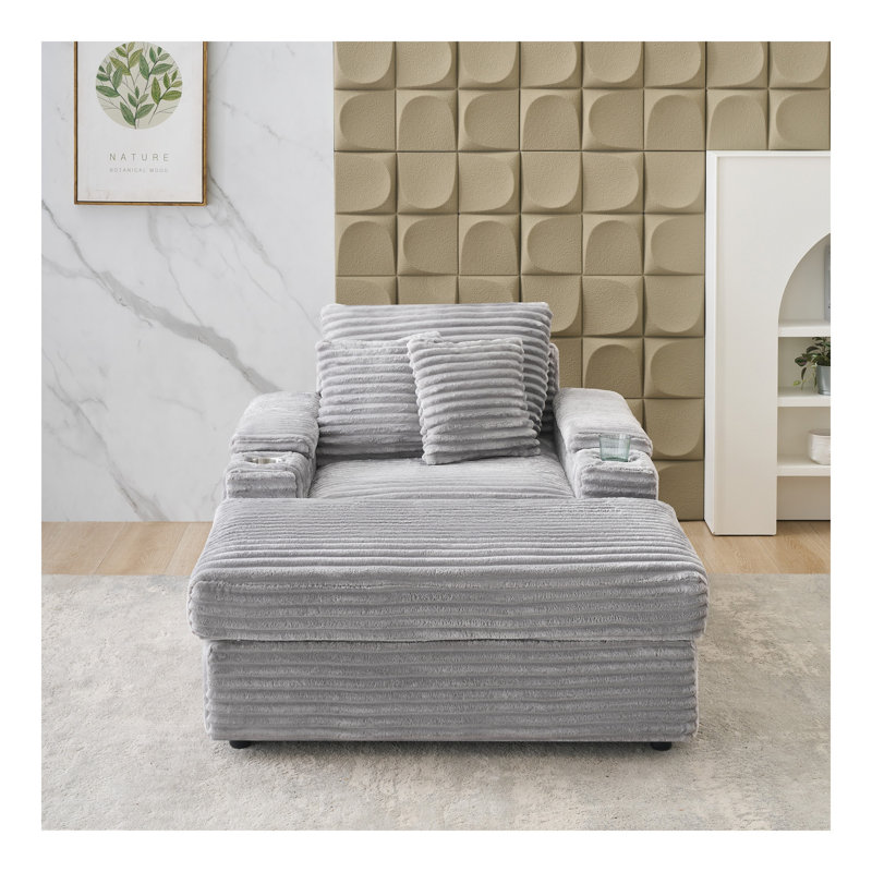Canapé simple en velours côtelé gris avec un coussin, deux coussins décoratifs, un repose-pieds et deux espaces de rangement