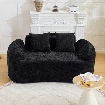 Black curved two - person compress sofa. It has armrests on both sides, comes with two pillows, is suitable for small - sized apartments, and can be placed in the living room or bedroom.