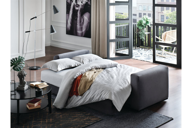 sofa bed folded down and made up with white bedding