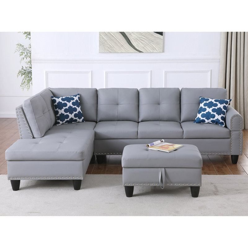 Canapé d'angle moderne en similicuir gris avec 3 sièges, dossier rembourré, garniture cloutée, 2 coussins décoratifs, porte-gobelet, rangement intégré et coussin porte-gobelet.