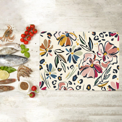Fleurs florales aux couleurs vives sur une planche de service en verre, idéales pour couper la viande et présenter des mets délicats