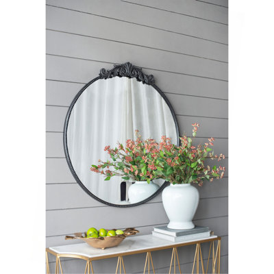 Miroir de conception classique avec forme ronde et cadre d'inspiration baroque pour la salle de bain, console de vestibule posée contre le mur