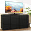Meuble télé noir à 4 portes cannelées avec prise électrique, 3 rangements réglables en panneaux de particules, multifonctionnel pour les espaces multimédias familiaux, design ondulé sans poignées, meuble de rangement pour loisirs