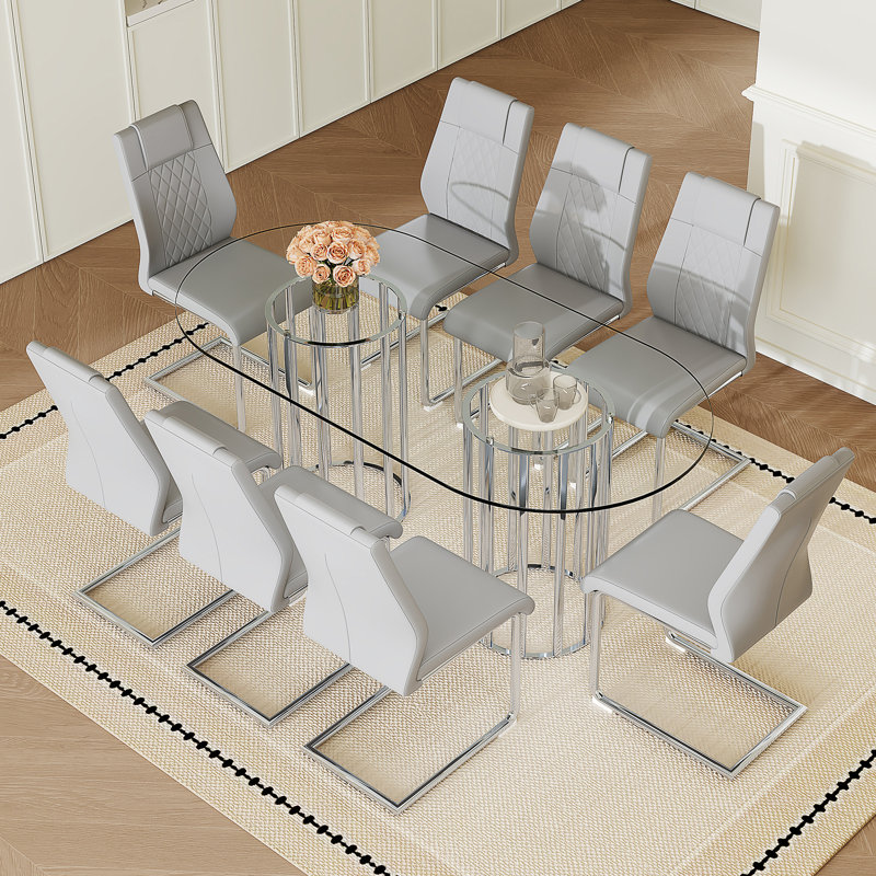 Ensemble de salle à manger 9 pièces, table ovale en verre trempé transparent de 180 cm, chaises à dossier haut en similicuir à motif quadrillé, piètement en métal argenté arqué, gris pâle