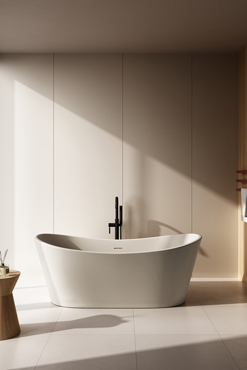 Modern white freestanding bathtub with black faucet in a sunlit neutral bathroom with tiled floors.