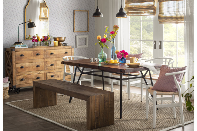 cute dining room with wood dining table and matching bench paired with white chairs and a wood buffet.