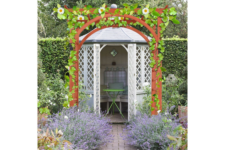 gazebo in a yard with an arbor in front of it