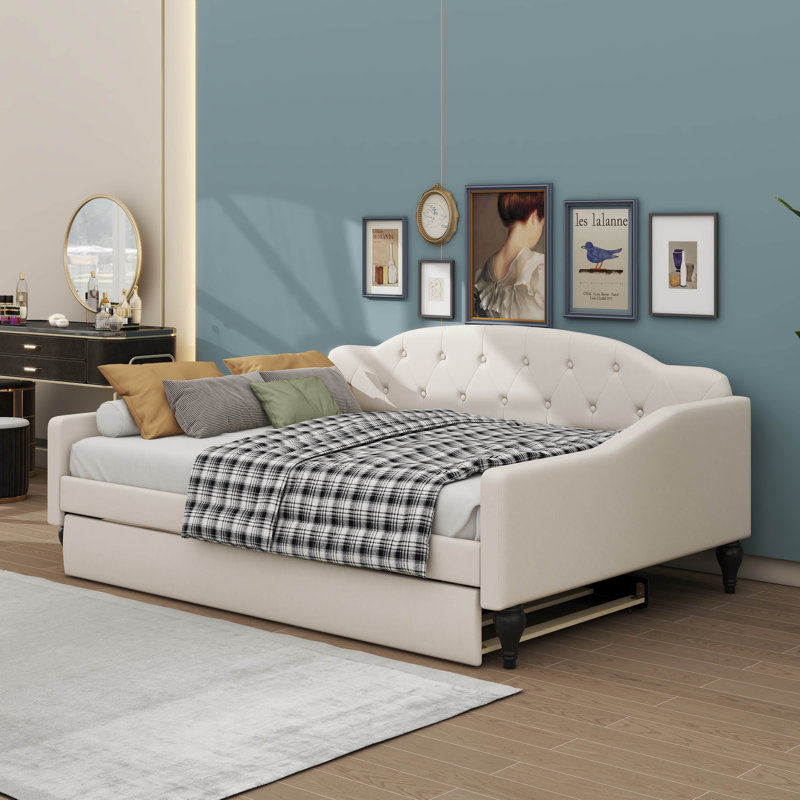 A Full-Size Upholstered Daybed With Tufted Design And A Built-In Twin-Size Trundle Bed