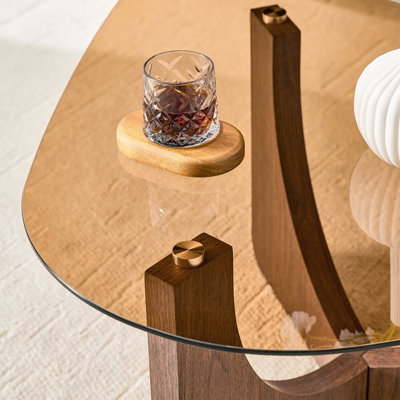 Table basse triangulaire de style rétro avec un plateau en verre trempé couleur thé et des pieds triangulaires en panneau de fibres à densité moyenne de couleur noyer. Idéal comme table d'appoint de canapé