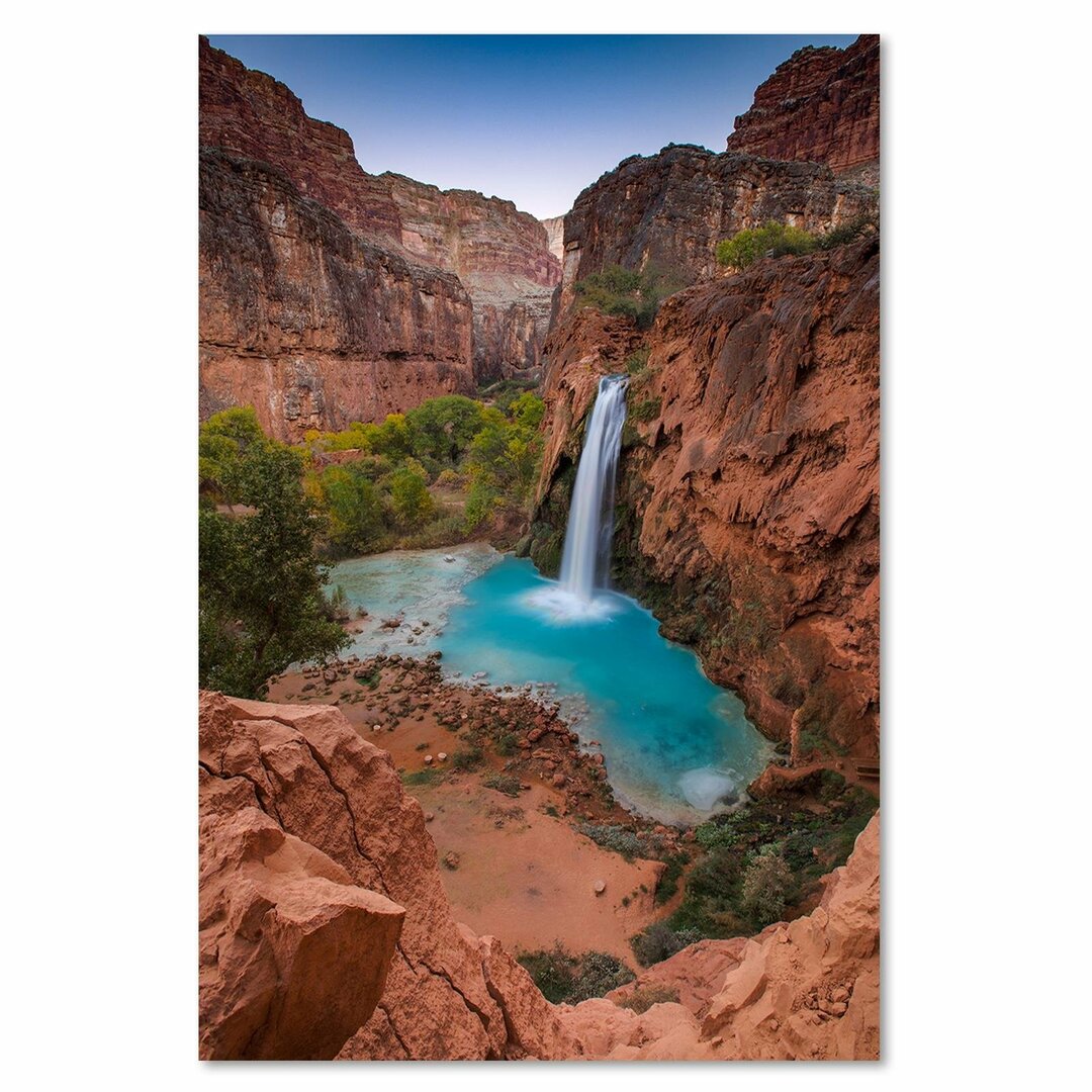 Leinwandbild Blauer Wasserfall zwischen den Felsen