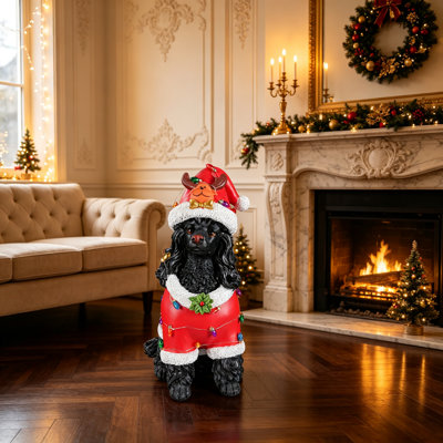 Statue festive de caniche noir de Noël en tenue de père Noël rouge, parfaite pour les décorations des Fêtes et les étalages joyeux