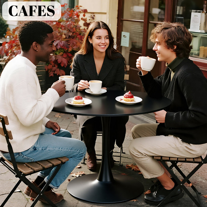 Une table de salle à manger ronde de style luxueux et noire, équipée d'une élégante base en métal en forme de tulipe et d'un plateau en panneau de fibres à densité moyenne de 31,5 pouces, présente un style médiéval moderne dans son ensemble. It