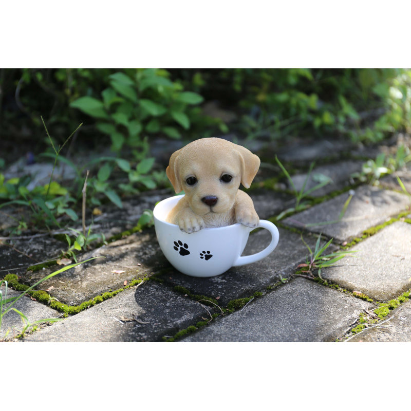 Statue chiot labrador dans une tasse de thé