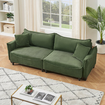 Tissu en velours côtelé vert, ce canapé peut être converti en canapé-lit avec deux coussins décoratifs
