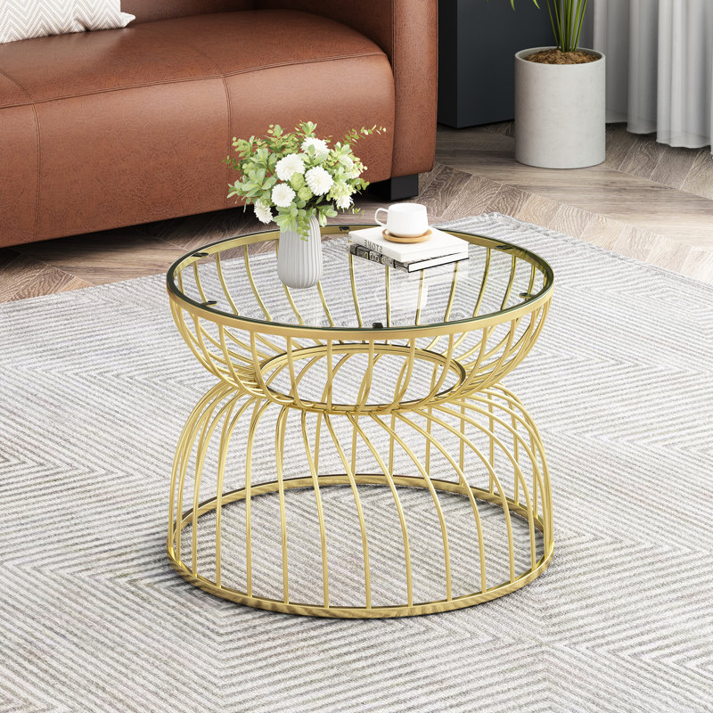 Table basse dorée attrayante, dessus en verre et piètement en métal, table essentielle de salon au design moderne et épuré.