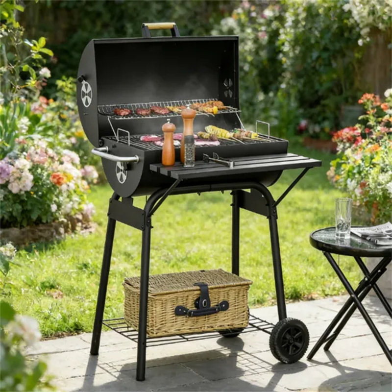 Barbecue au charbon de bois en acier au carbone noir, idéal pour les pique-niques à l'extérieur, avec grille de maintien au chaud, bac à charbon réglable sur 4 niveaux, récupérateur de cendres, étagères de rangement et roulettes de déplacement.