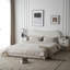 Lit tapissier blanc moelleux avec tête de lit ondulée et coutures verticales, très grand