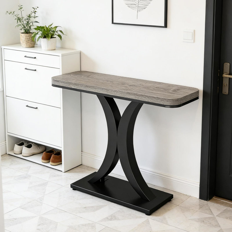 Table d'entrée de style industriel moderne, console compacte avec piètement en bois épais et incurvé, idéale pour le salon, le bureau ou le couloir. Longueur : 100 cm (39,4 po). Plateau design et lignes géométriques allongées.