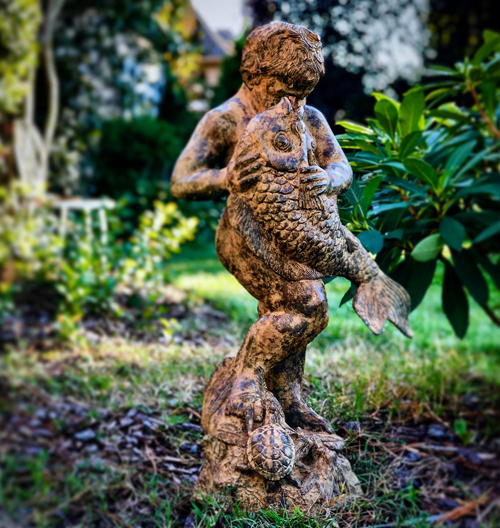 marble statue of a little boy proudly squeezing the large fish he caught  surrounded by purple catmint in historic garden at Shelburne Farms ,  Vermont Stock Photo - Alamy