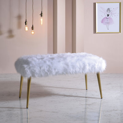 Élégant banc rembourré en fausse fourrure blanche avec des pieds en métal doré brillant pour une chambre à coucher moderne et luxueuse