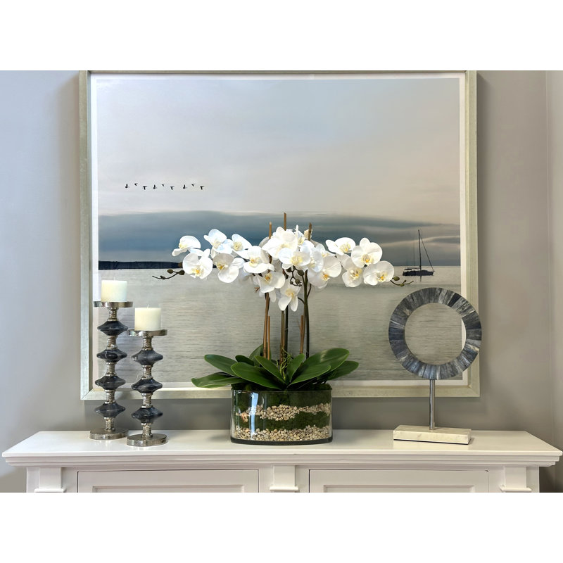 Orchids And Leaves Arranged In An Oblong Clear Glass With Moss And Rocks