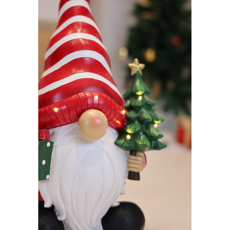 Père Noël tenant un sapin de Noël illuminé à l'intérieur et à piles