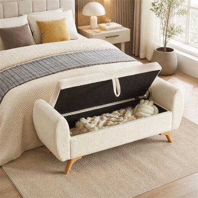 Banc de rangement moderne en velours côtelé avec pattes en bois massif et siège rabattable, idéal pour une chambre ou une entrée.