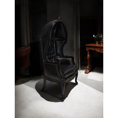 Fauteuil capitonné en similicuir noir capitonné