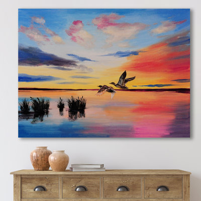 Grues volant pendant un coucher de soleil coloré - peinture sur toile