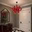 Lustre contemporain en verre rouge avec bras sculpturaux incurvés et accents chromés