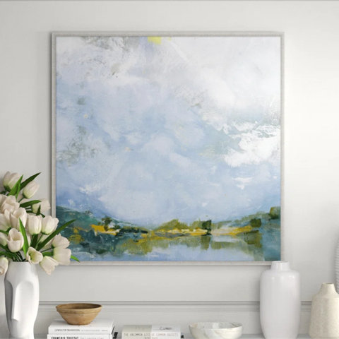Framed landscape painting over books and vases.