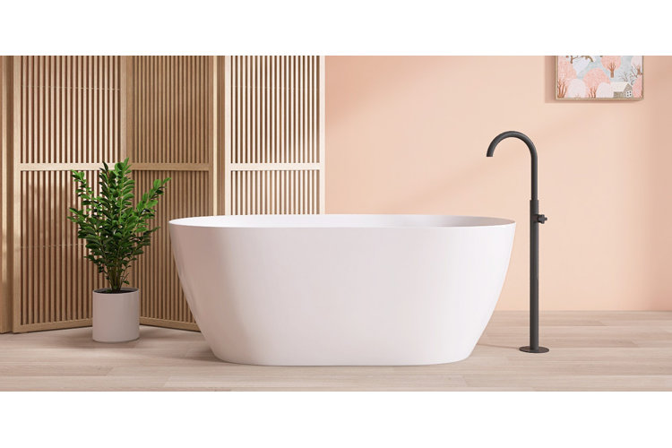 beige wall bathroom with a white freestanding bathtub with a black freestanding faucet