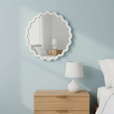 Un miroir mural rond blanc avec un cadre ondulé, adapté aux salons, aux chambres et aux salles de bain.