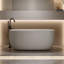 Baignoire îlot en résine effet pierre beige, lisse et arrondie, offrant une excellente isolation pour un bain relaxant. Matériau résistant à l'usure et facile à nettoyer.