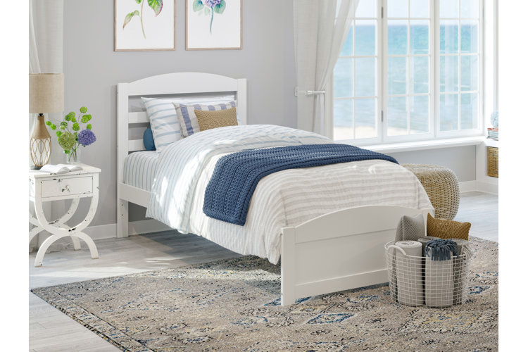 a twin bed in a coastal style bedroom with a standard pillow and two decorative pillows