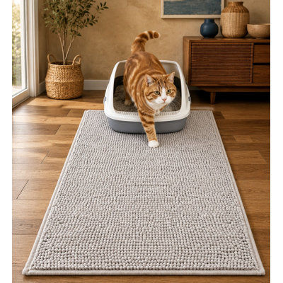 This ultra-absorbent 28 x 22 in soft chenille litter box mat uses long plush chenille for deep trapping, while a waterproof TPR anti-slip backing helps manage moisture; the mat absorbs moisture and is machine washable.