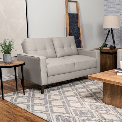 Petit beige tapissier avec détails auto-tissés, dossier quadrillé et accoudoirs, pour les espaces de vie principaux