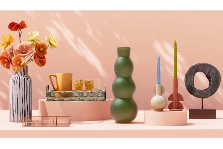 Colorful inexpensive home decor arrangement with vases, candles, tray, and flowers styled on a peach backdrop for budget decorating ideas