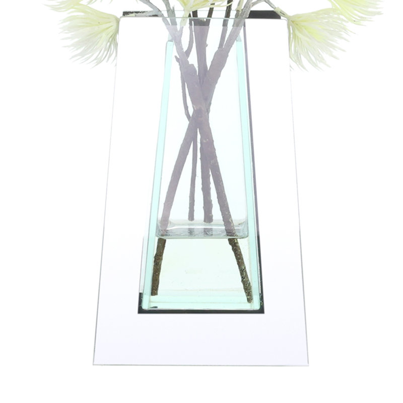 Thistle et saule disposés dans un vase miroir en verre