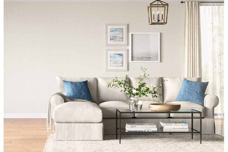 white linen chaise sectional over an ivory area rug in a coastal living room with shiplap walls